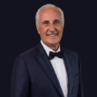 Headshot of Christian Mahe de Berdouare, founder of diGeniusAI, wearing a tuxedo against a dark background.